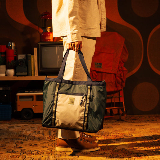 General lookbook model shot of Mountain Utility Tote in "Forest / Bone White"